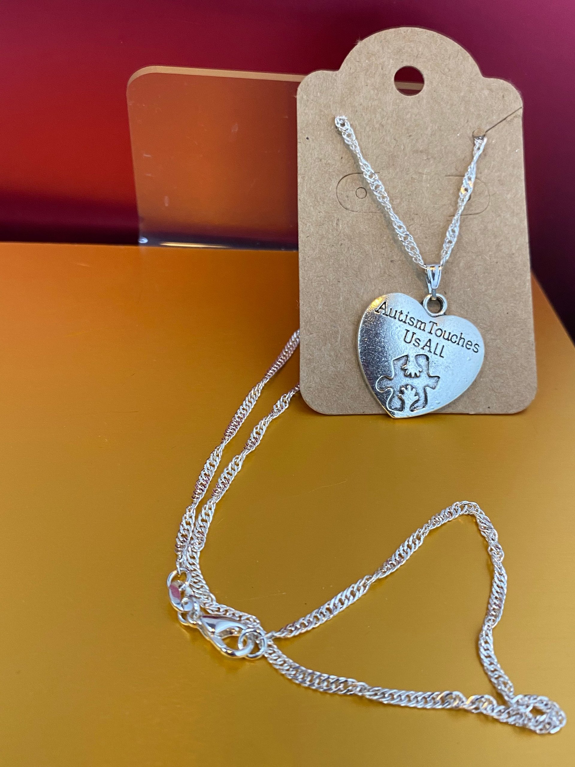 Silver necklace with Autism awareness message
